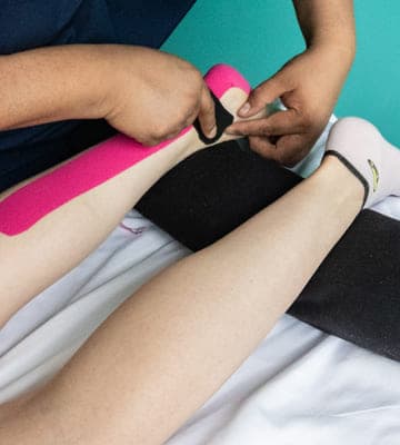 cintas de Kinesiotape en un pie , el fisioterapeuta trabaja 