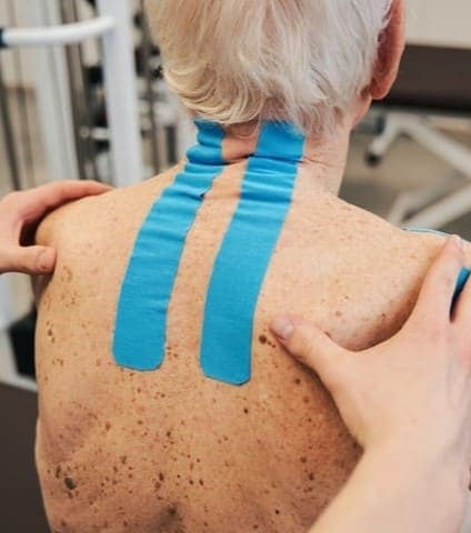 adulto mayor con cinta Kinesiotape en la espalda 