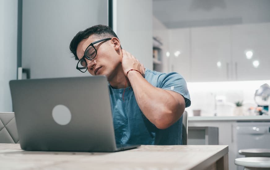 joven frente al computardor con problemas de cervical