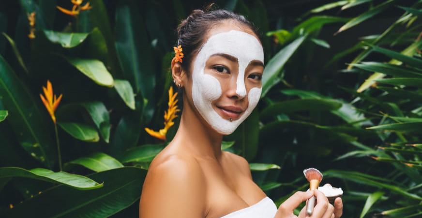 chica sentada en cama con dolor de cervicales